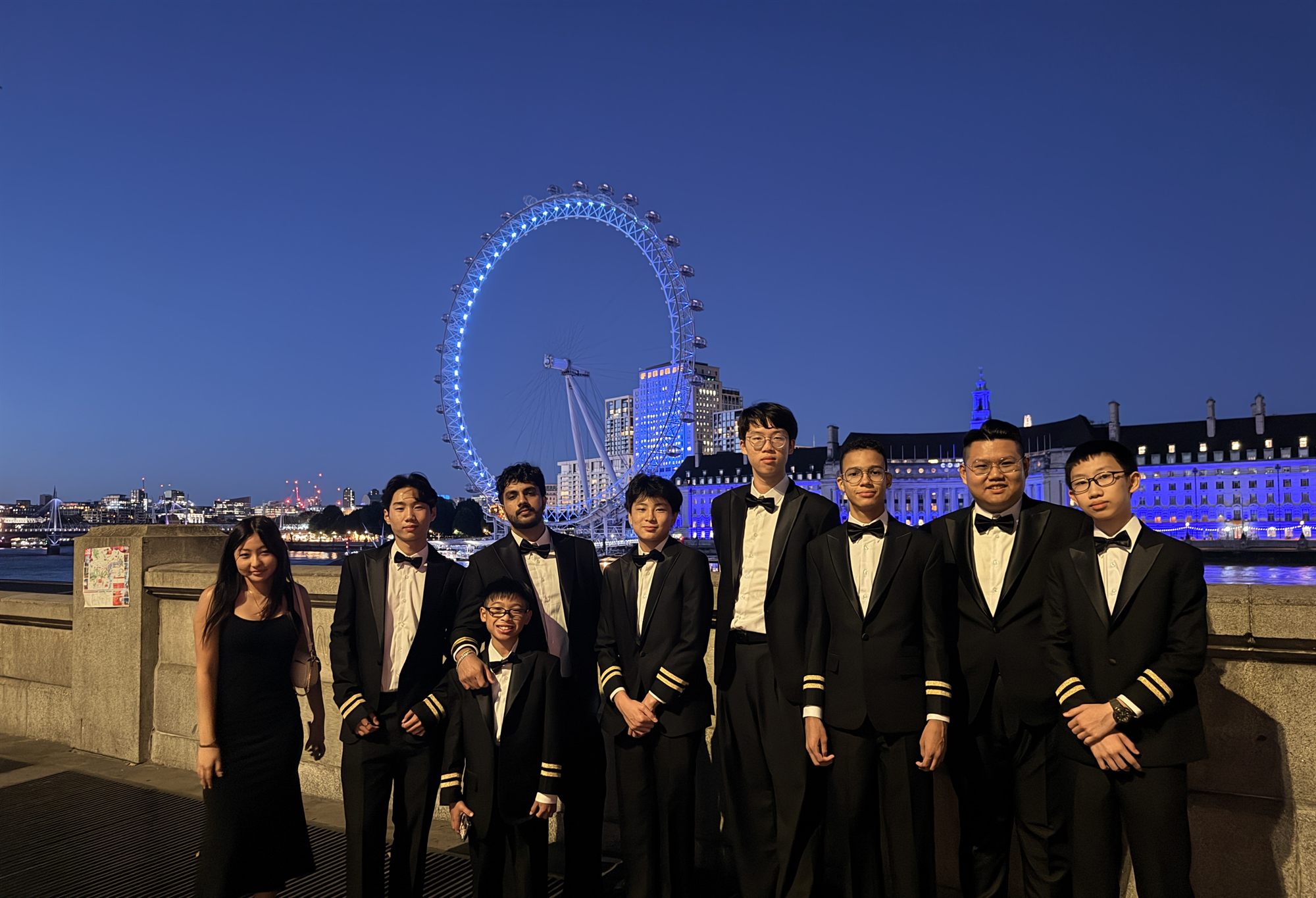 HKPAPA Global Bridge students in uniform in front of the London Eye at dusk