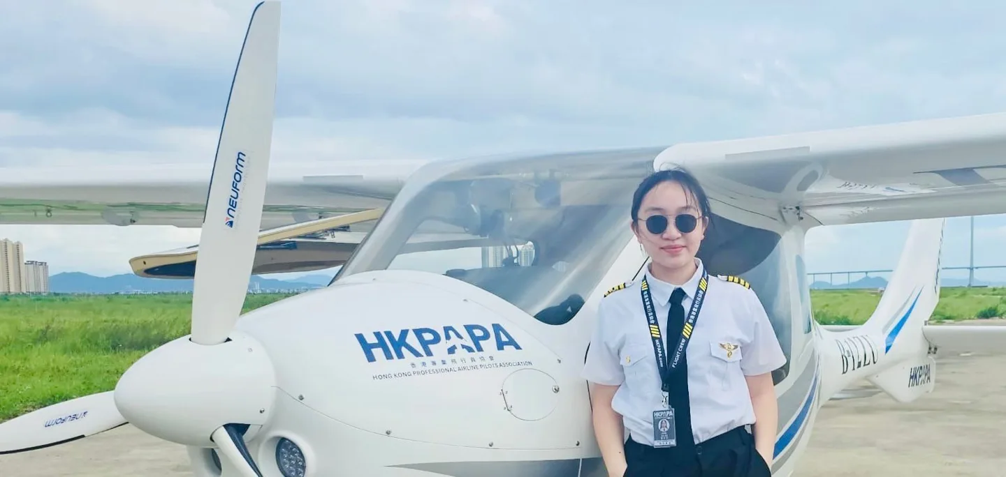 Female student pilot beside a training aircraft